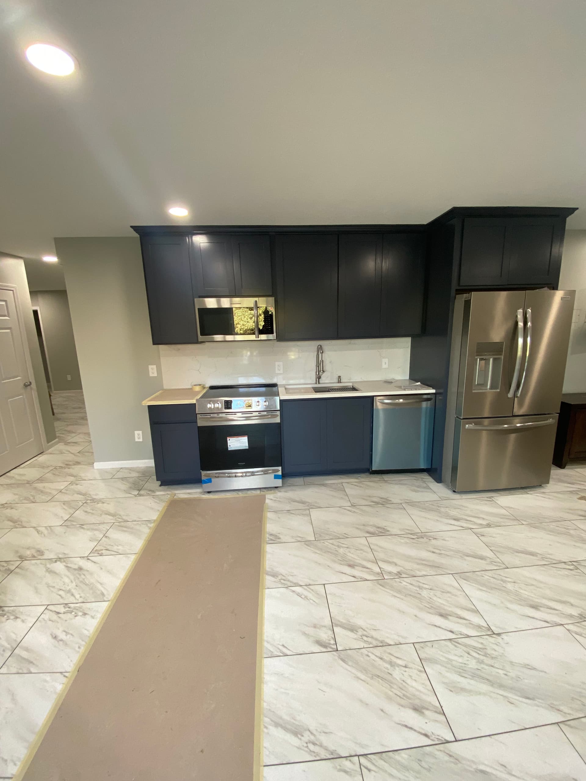 Dark Cabinets and Marble Floors Make This Basement Kitchen Pop image